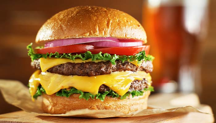 A Green Bay favorite: a cheeseburger with lettuce, tomato, onion, and two beef patties on a bun.